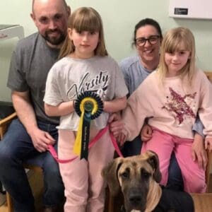 Family of a man, woman and two young girls with their dog